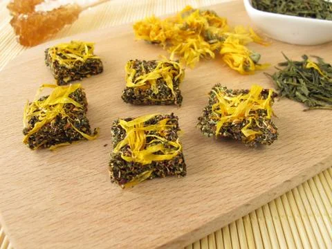 Tea bricks made of pressed green and marigold flowers Stock Photos