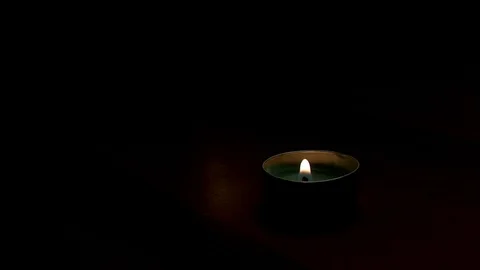 Tea candle flame extinguished in dark room Stock Footage 106763912