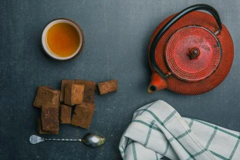 Tea composition with marshmallow, tea cup and traditional teapot on dark back Stock Photos