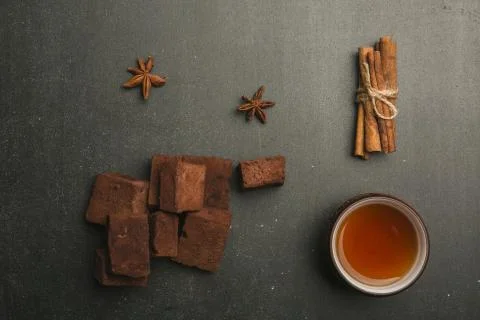 Tea composition with marshmallow, tea cup and traditional teapot on dark back Stock Photos