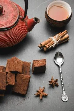 Tea composition with marshmallow, tea cup and traditional teapot on dark back Stock Photos
