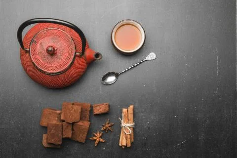 Tea composition with marshmallow, tea cup and traditional teapot on dark back Stock Photos