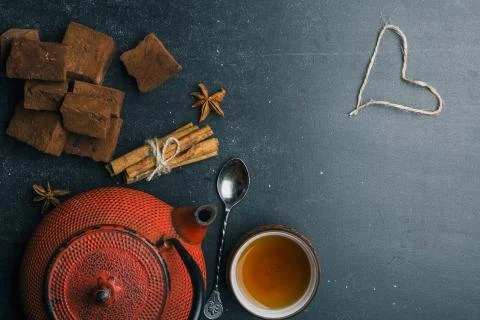 Tea composition with marshmallow, tea cup and traditional teapot on dark back Stock Photos