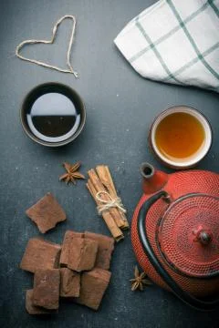 Tea composition with marshmallow, tea cup and traditional teapot on dark back Stock Photos