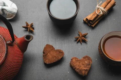 Tea composition with marshmallow, tea cup and traditional teapot on dark back Stock Photos