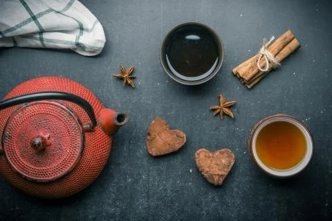 Tea composition with marshmallow, tea cup and traditional teapot on dark back Stock Photos