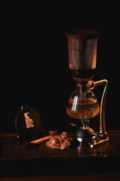 Tea composition. Puer tea in the siphon with Buddha statue on black backgroun Stock Photos