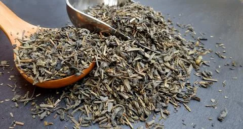 Tea composition with spoons on dark background Stock Photos