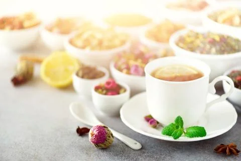 Tea concept with copy space. Different kinds of dry tea in white ceramic bowls Stock Photos