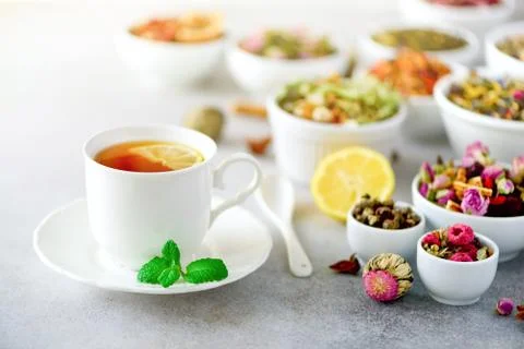 Tea concept with copy space. Different kinds of dry tea in white ceramic bowls Stock Photos