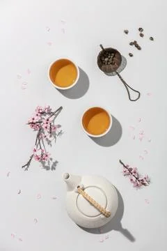 Tea concept, two white cups of tea and teapot on concrete background Stock Photos