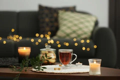 Tea, cookies and decorative elements on wooden table in living room Stock Photos