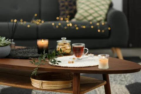 Tea, cookies and decorative elements on wooden table in living room Stock Photos