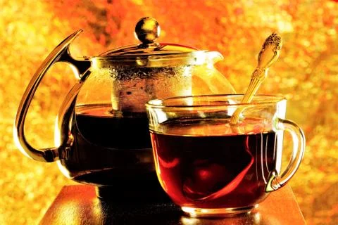 Tea in a Cup and teapot on the background of rainbow lights. Stock Photos