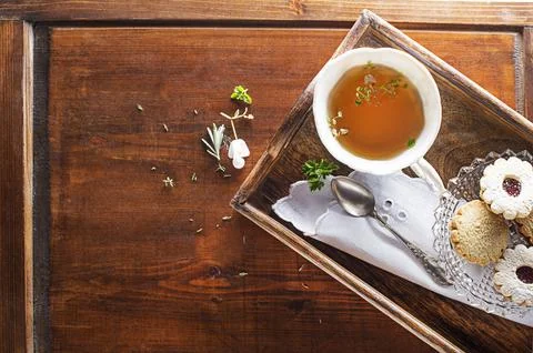 Tea cup with herbal leaves serving with cookies Stock Photos
