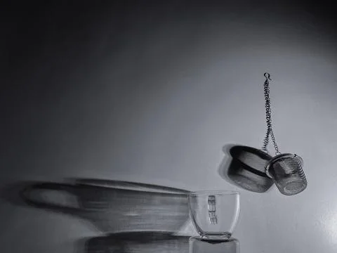 Tea Cup With Infuser Casting Shadow On Wall Black And White Foto stock