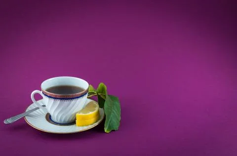 Tea cup lemon leaf colored closeup Stock Photos