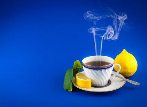Tea cup lemon leaf colored closeup Stock Photos