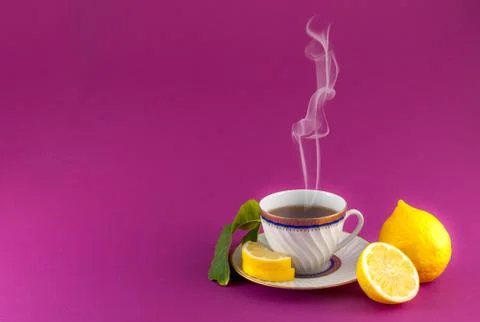 Tea cup lemon leaf colored closeup Stock Photos