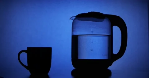 Tea Cup placed on table next to electric tea kettle Stock Footage 157742633