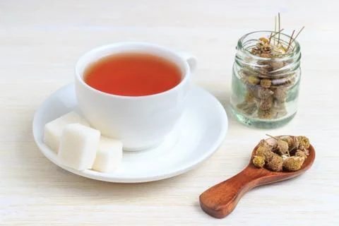 Tea in a cup with a sugar cube and a wooden spoon Stock Photos