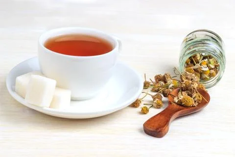 Tea in a cup with a sugar cube and a wooden spoon Stock Photos