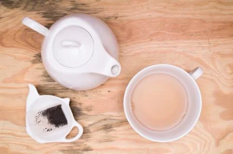 Tea cup, tea kettle, small tray and used tea bag Stock Photos