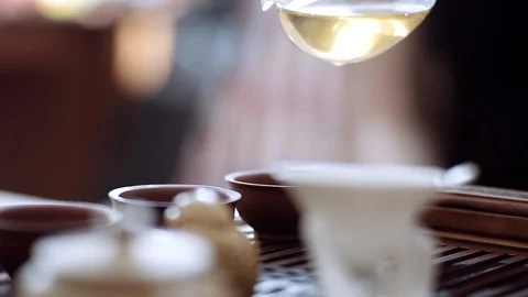 In tea cups on a wooden table poured a fragrant tea. Tea ceremony Stock Footage 115961415