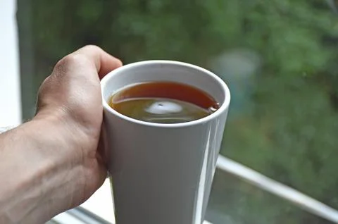Tea drinking. man holding a cup of hot tea or coffee in his hands Stock Photos