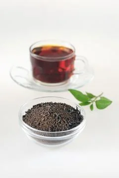 Tea dust in pot with tea cup on white background Stock Photos