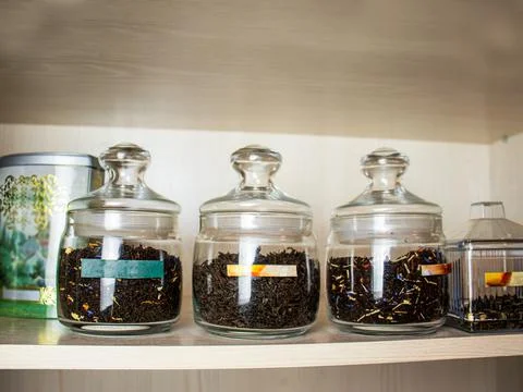 Tea in glass jars, different types of herbal tea in glass bottles on a shelf Stock Photos