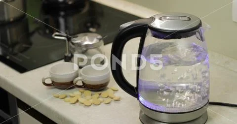 Tea kettle with boiling water. Tea bags and sugar on the background Stock Photos