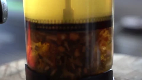 Tea leaves are brewed, tea drink. Close-up, tea leaves in a glass beaker. Video stock 209161374