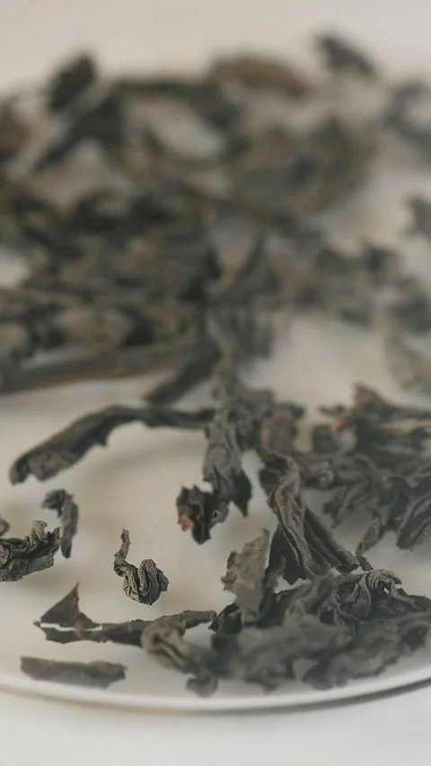 Tea leaves fall into a transparent container. Vertical video. Stock Footage 325704840