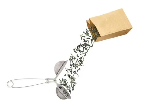 Tea leaves falling into tea strainer 스톡 사진