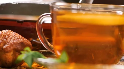 Tea with lemon and mint and muffin on breakfast table Stock Footage 104092583