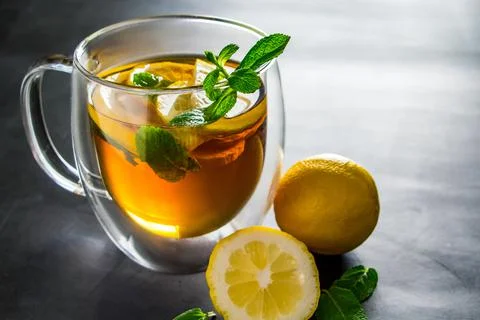 Tea with lemon and mint in transparent cup. Alternative medicine for treatmen Stock Photos