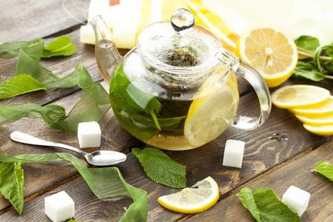 Tea with lemon and mint in a transparent teapot Stock Photos