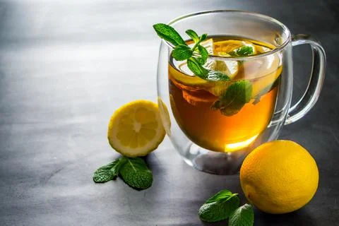 Tea with lemon and mint in transparent cup. Alternative medicine for treatmen Stock Photos