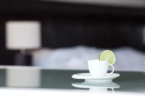 Tea with lemon on the background of the bed and the lamp Stock Photos