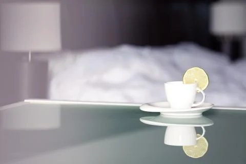 Tea with lemon on the background of the bed and the lamp Stock Photos