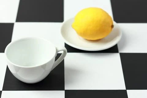 Tea with lemon on a chessboard. Stock Photos