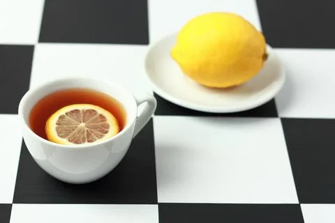 Tea with lemon on a chessboard. Stock Photos