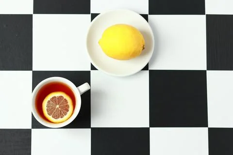 Tea with lemon on a chessboard. Stock Photos