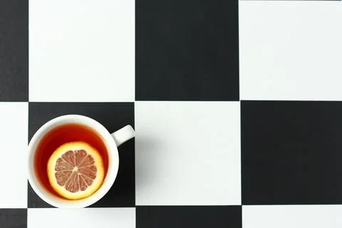 Tea with lemon on a chessboard. Stock Photos