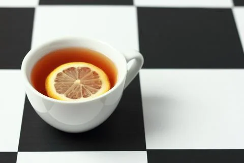 Tea with lemon on a chessboard. Stock Photos