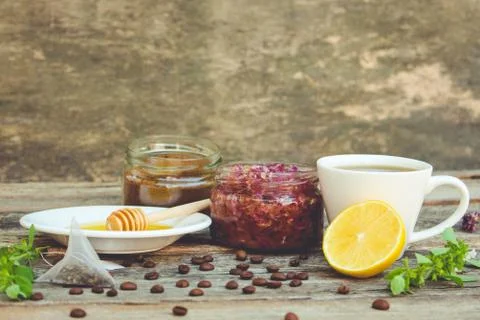 Tea, lemon, mint, jam made of rose petals, honey. Toned image. Stock Photos