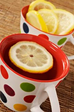 Tea with lemon in polka dot cups Stock Photos