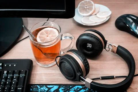 Tea with lemon on the table near the computer. Stock Photos