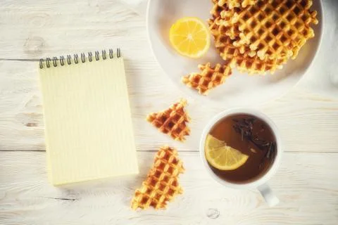 Tea with lemon, wafer and notepad. Copyspace 库存照片